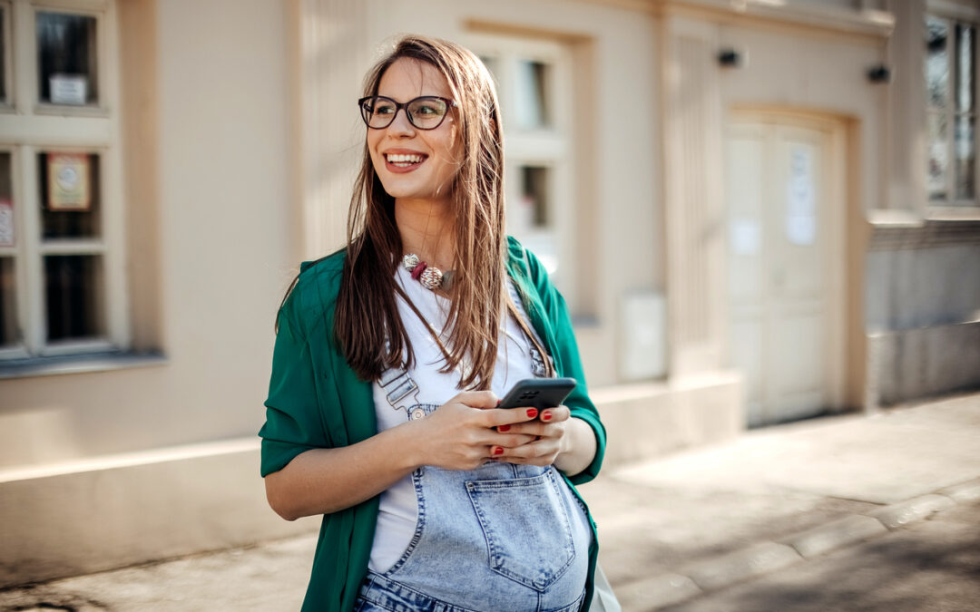 Schwangere Frau mit Telefon